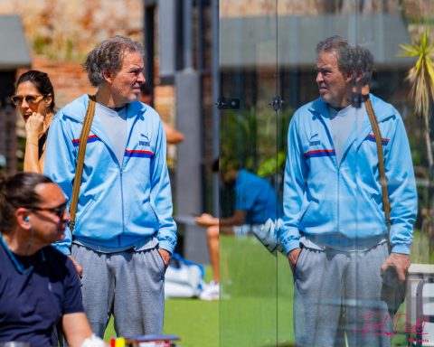 Gute Laune bei Padel-Camps in Spanien Mann im blauen Sportanzug steht vor einer Glaswand und reflektiert sein Spiegelbild.